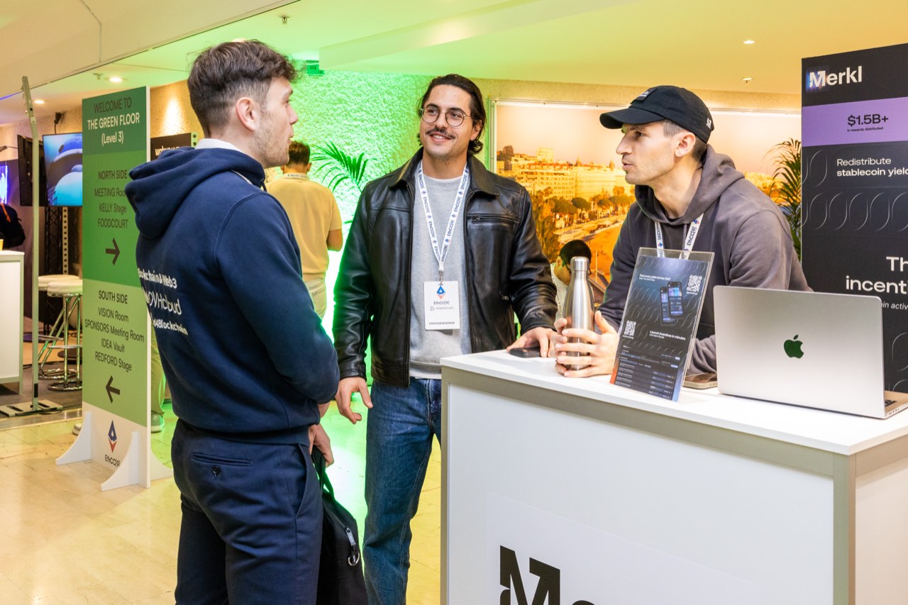 Members of the Merkl team talking with visitors at the Merkl booth during EthCC